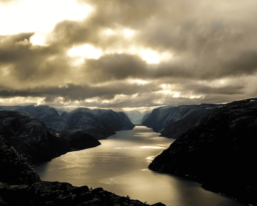 A photo of overcast sky, mountains and river in Norway